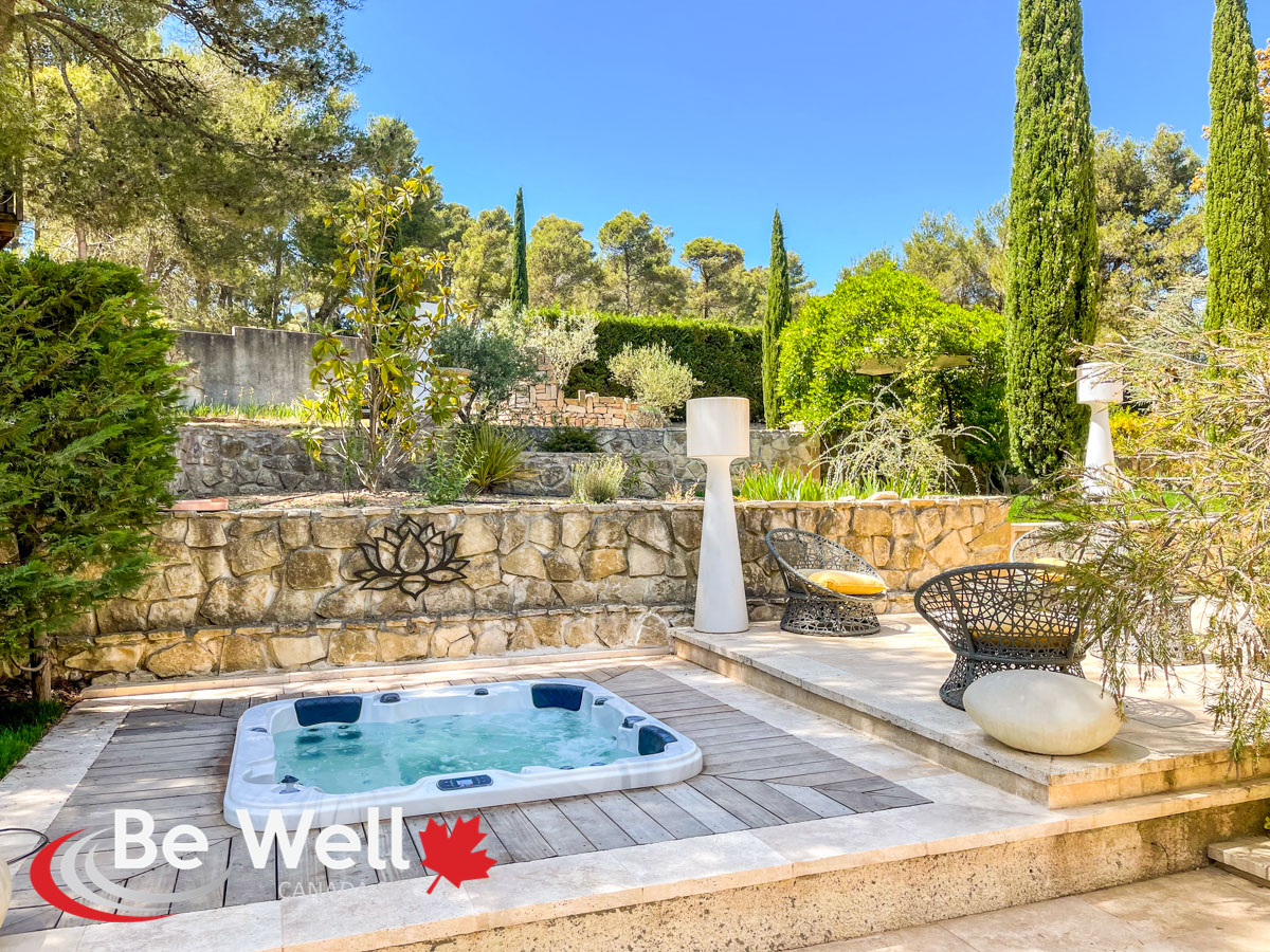 Spa Be Well encastré dans un jardin provençal avec terrasse en pierre et végétation méditerranéenne